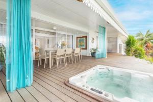 an indoor hot tub on a deck with a table and chairs at Luxurious 4BR Villa in Vairoa