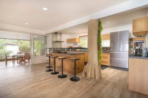 a kitchen with stools and a table in a room at Luxurious 4BR Villa in Vairoa