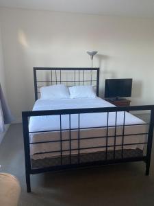 a bed with a black frame and a desk at Divinity Hut in Brampton +7 photos