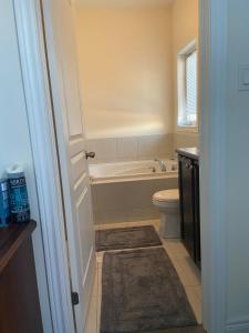 a bathroom with a tub and a toilet and a sink at Divinity Hut in Brampton