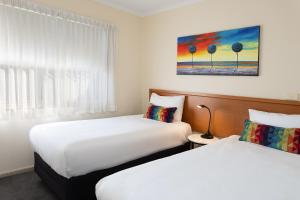 a hotel room with two beds and a window at Quest Tamworth in Tamworth