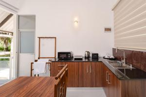 a kitchen with wooden cabinets and a counter top at Madiha Beach Resort in Matara