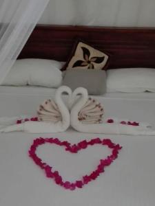 a bed with two heart decorations on it at Feel side villa in Induruwa