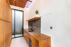 a kitchen with white walls and a wooden counter top at Anasera Villas Echo Beach Canggu in Canggu +36 photos