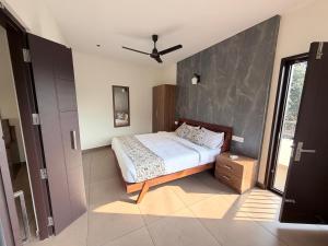 a bedroom with a bed and a ceiling fan at Cozy Nook Inn - A BB Linens Experience in Vythiri