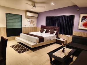 a bedroom with a king sized bed and purple walls at Pentagon Next Bhubaneswar in Bhubaneshwar
