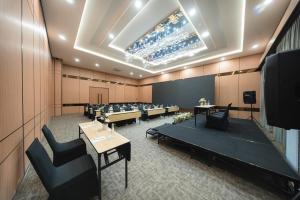 a conference room with tables and chairs and a ceiling at Horison IJ Kudus in Kudus +34 photos
