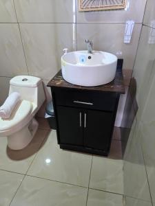a bathroom with a sink and a toilet at Jannah Cabaña romántica con jacuzzi in Ángeles