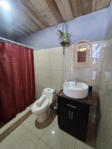 a bathroom with a toilet and a sink at Jannah Cabaña romántica con jacuzzi in Ángeles