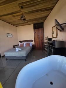 a bathroom with a bed and a tub in a room at Jannah Cabaña romántica con jacuzzi in Ángeles