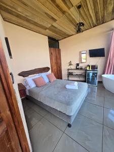 a bedroom with a bed and a sink and a tub at Jannah Cabaña romántica con jacuzzi in Ángeles