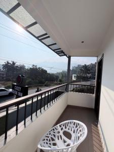 a balcony with a white chair and a view at Cozy Nook Inn - A BB Linens Experience in Vythiri