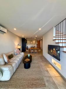 a living room with a couch and a tv at The Menuai Bali Villas Canggu in Canggu