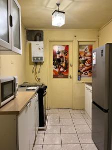 a kitchen with a refrigerator and a microwave at Cochrane hostal in Los Ángeles