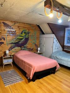 a bedroom with a bird painted on the wall at Cochrane hostal in Los Ángeles