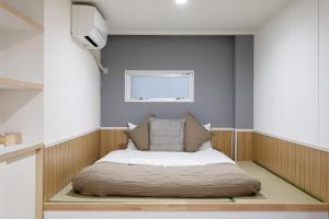 a bed in a room with a tv on the wall at 金洲House 懿-下寺 in Osaka +84 photos