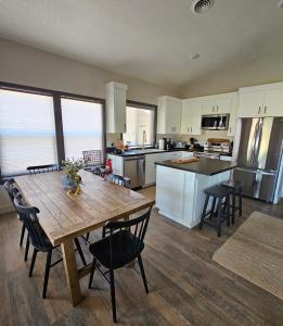 a kitchen and dining room with a wooden table and chairs at Charming New Lake House in Pierre