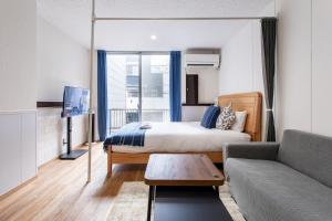 a bedroom with a bed and a living room with a couch at 金洲House 懿-下寺 in Osaka