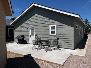 a patio with a table and chairs and a grill at Charming New Lake House in Pierre