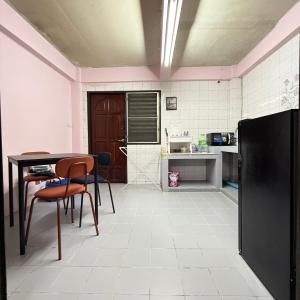 a kitchen with a table and chairs and a refrigerator at REHome in Bangkok
