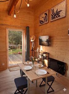 a wooden dining room with a table and a window at Gîtes Hydra Charme et Nature proche Honfleur en Normandie in Conteville