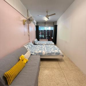 a bedroom with a bed and a couch with a yellow toy at REHome in Bangkok