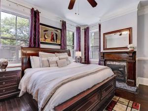 a bedroom with a large bed and a fireplace at Historic Savannah Condo, Sleeps 6, Pool, Dogs Ok in Savannah