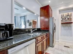 a kitchen with a sink and a refrigerator at Historic Savannah Condo, Sleeps 6, Pool, Dogs Ok in Savannah +16 photos