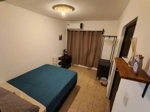ein Schlafzimmer mit einem blauen Bett in einem Zimmer in der Unterkunft SweetHome con amplio y fresco patio in Tampico