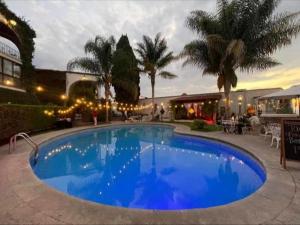 a large blue swimming pool in front of a building at hotel la ermita suites in San Miguel de Allende +25 photos