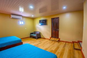 a room with two beds and a chair in it at The Social Fortuna in Fortuna