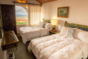 a hotel room with two beds and a window at hotel la ermita suites in San Miguel de Allende