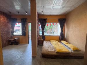 a bedroom with a bed in a room with windows at Homestay River Green in Làng Lap