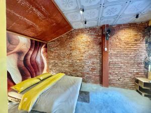 a room with a bed and a brick wall at Homestay River Green in Làng Lap