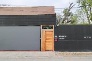 a garage with a wooden door and a black wall at Chiang Mai Private "Davin Pool Villa" CNX 2km to Central Festival in Chiang Mai