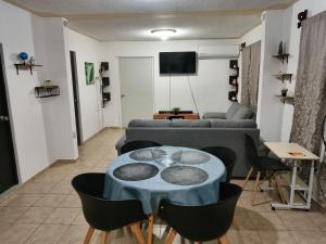 ein Wohnzimmer mit einem Tisch und einem Sofa in der Unterkunft SweetHome con amplio y fresco patio in Tampico