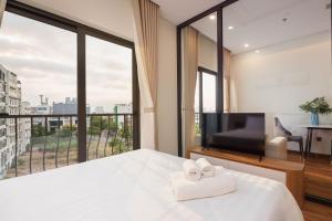 a bedroom with a bed and a large window at BRIO Ventura Apartment in Danang