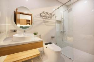 a bathroom with a toilet and a sink and a mirror at BRIO Ventura Apartment in Danang +63 photos
