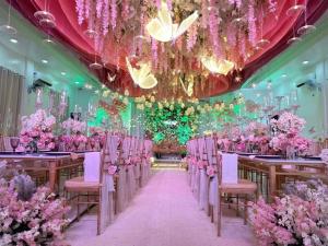 a banquet hall with pink chairs and pink flowers at The Avenue Hotel and Event Center in Manaoag