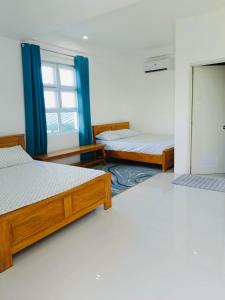 a room with three beds and a window at The Avenue Hotel and Event Center in Manaoag