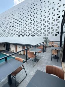 a balcony with tables and chairs and a pool at ไดมอนด์ โฮเทล in Ban Krasang