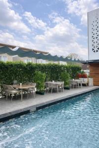a pool with tables and chairs next to a building at ไดมอนด์ โฮเทล in Ban Krasang