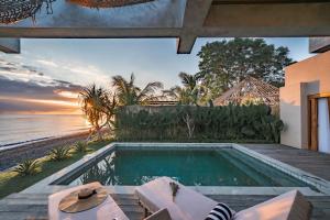 a swimming pool with a view of the ocean at Salty Breeze Amed in Ambat