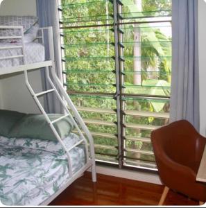 a bedroom with a window and a bunk bed at Elevated Tropical House in Casuarina +15 photos