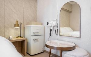 a room with a white refrigerator and a mirror at the stay in Seoul
