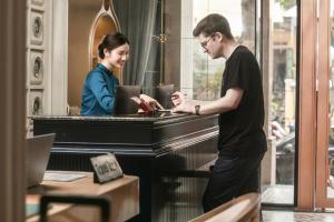 a man and a woman standing next to a piano at Solar Premium Hotel & Spa in Hanoi +79 photos