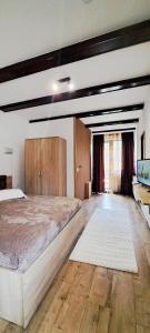 a bedroom with a large bed and wooden cabinets at Vila Silvana in Moieciu de Jos