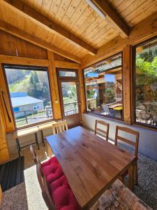 a wooden table and chairs in a room with windows at JIROTOVY BOUDY II in Telnice
