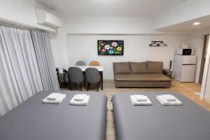 a living room with two beds and a couch at Lucky NAMBA 大阪難波 なんば in Osaka