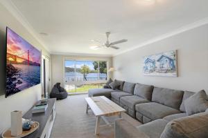 a living room with a couch and a table at Waterside Escape St Hubert s Island in Saint Huberts Island
